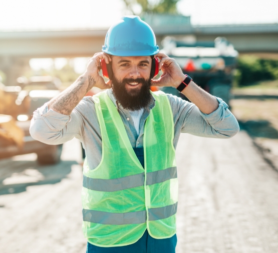 Construction worker putting on noise-canceling headphones